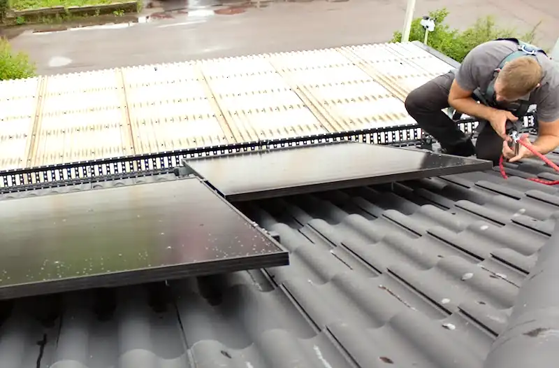 Besiktningsman kontrollerar solceller på villatak.